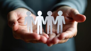 Hands holding paper cutouts of people holding hands. Concept of employee assistance programs support, care. Care for employees well-being, personal issues. Confidential support systems. Crisis