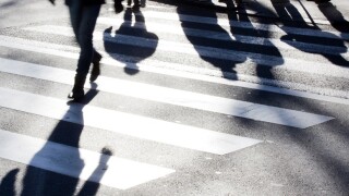Blurry zebra crossing with pedestrians making long shadows