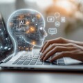 Person uses laptop interacting with AI virtual assistant. AI head graphic overlay laptop keyboard. Concept of AI prompt engineering, LLM. Person types on keyboard to communicate with virtual