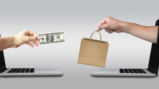 Hand coming out of a laptop paying for goods being delivered out of another laptop