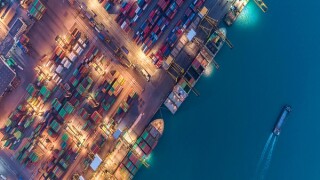 Container ship in export and import business and logistics. Shipping cargo to harbor by crane. Water transport International. Aerial view