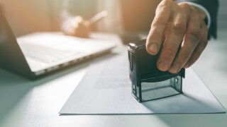 businessman put a stamp on business contract in office