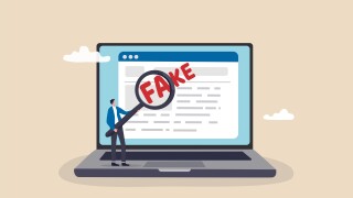 Fake news or false information spreading on website and social media, screening or verify truth before sharing or believe concept, man with magnifying glass verify fake news on website on computer.