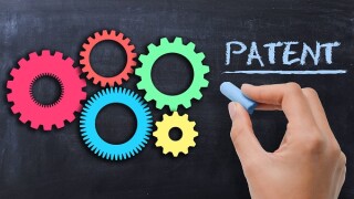 Industrial patent protection concept with gears on blackboard