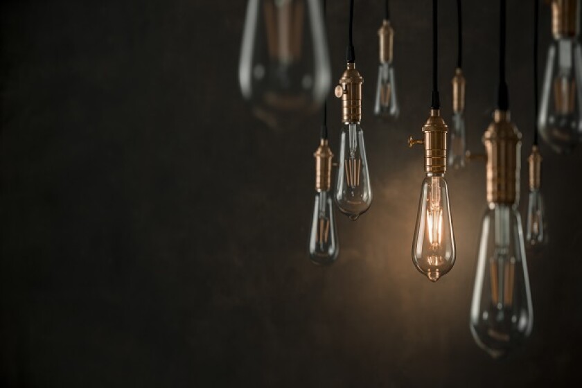 Individuality concept, one bright light bulb standing out from t