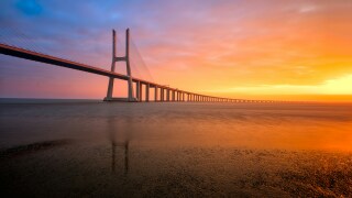 Sunset over Lisbon bridge stretching into the distance.jpg