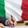 Judge writing on paper in courtroom with Italy flag background. Wooden gavel of equality theme and legal concept.