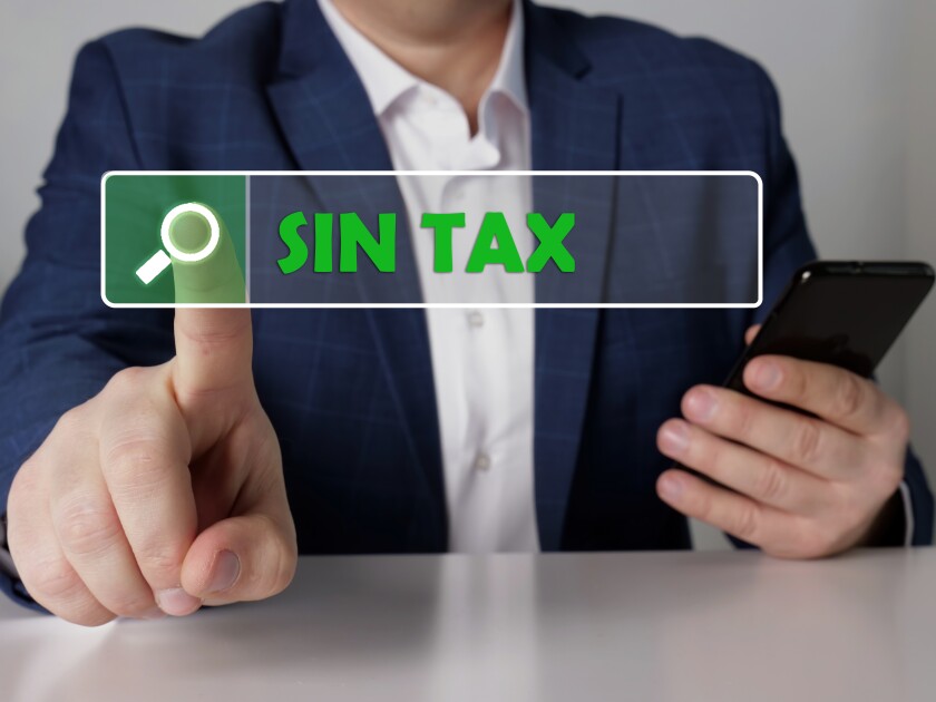 SIN TAX text in search line. Businessman looking for something at smartphone. SIN TAX concept.