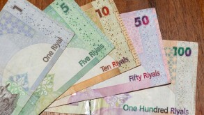 A close up of the  currency of Qatar or  the Qatari Riyal notes of cash spread out on the white background. Money exchange.