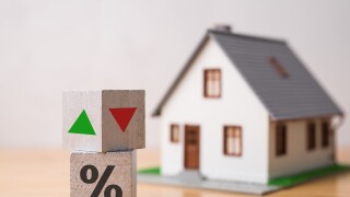 Wooden blocks percentage sign, arrow up and down with house model background. Central bank FED control interest rate increase or decrease effect to house price, monthly payment, buying home concept.