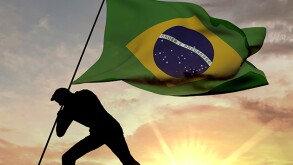 Brazil flag being pushed into the ground by a male silhouette. 3