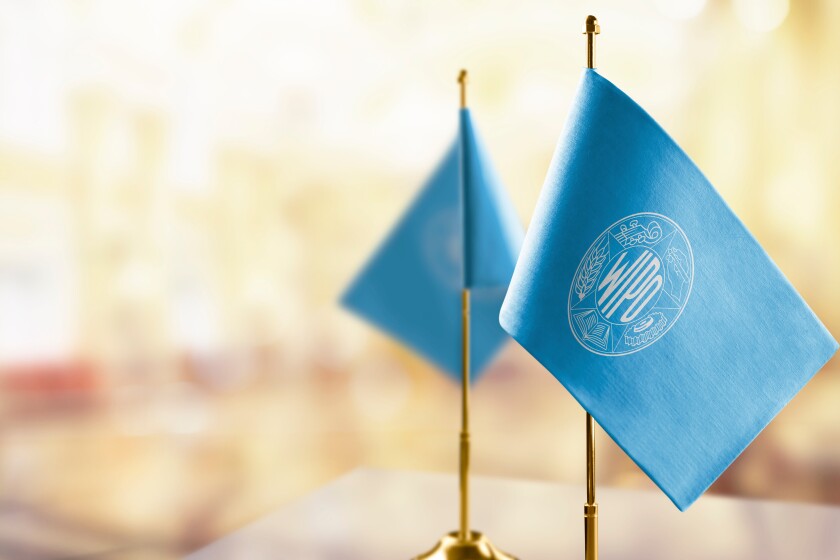 Small flags of the International Intellectual Property Organization on an abstract blurry background