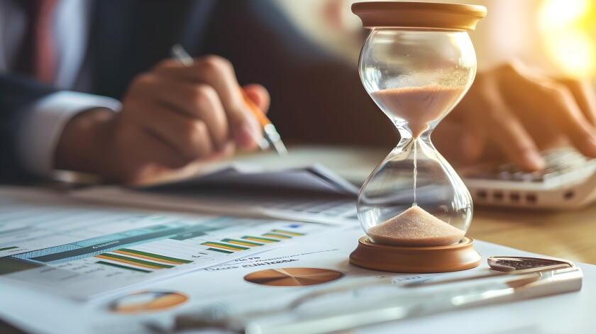 Hourglass on a business  desk and important documents