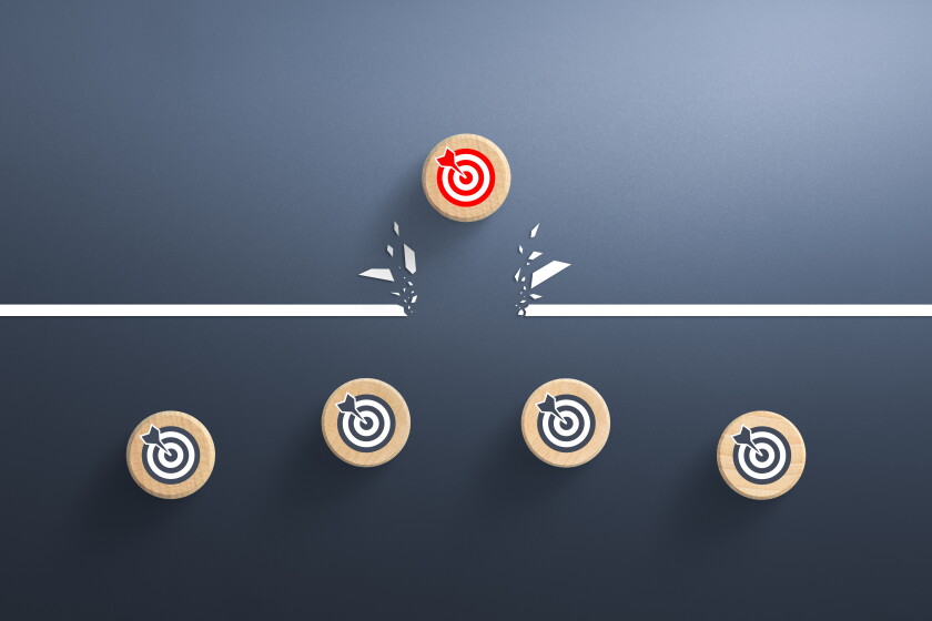 Target icon on wooden cube breaking through obstacle, Concept of overcoming barriers, goal