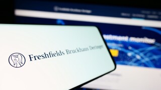 Stuttgart, Germany - 12-17-2023: Mobile phone with logo of British law firm Freshfields Bruckhaus Deringer LLP in front of business website. Focus on left of phone display.