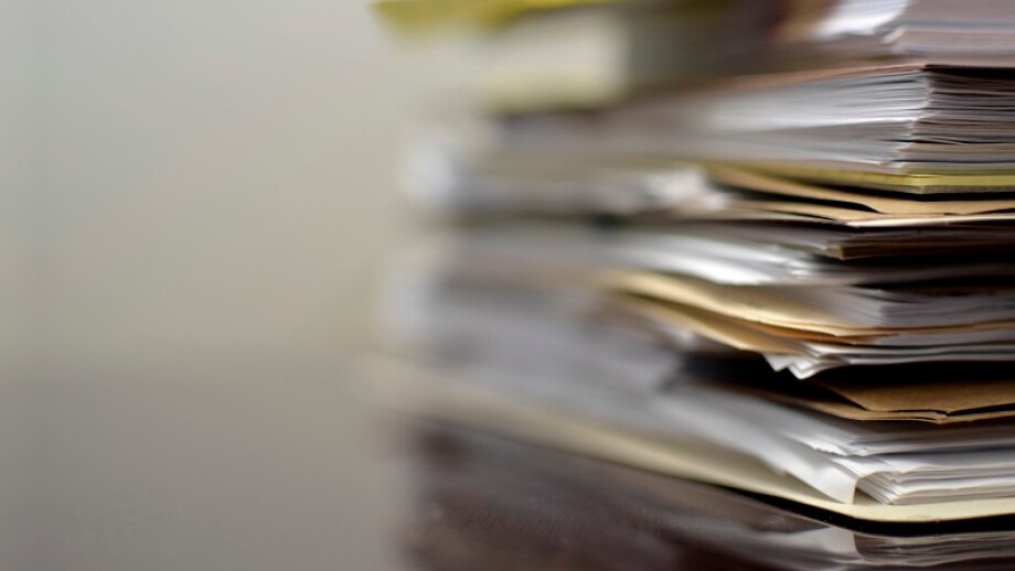 Stacks of Files on Desk Waiting to be Completed Business Work