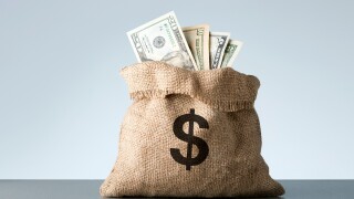 Burlap with dollar banknotes on gray background. Bribe or bonus