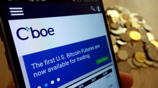KONSKIE, POLAND - MAY 14, 2018: CBOE Global Markets website displayed on smartphone and stack of coins