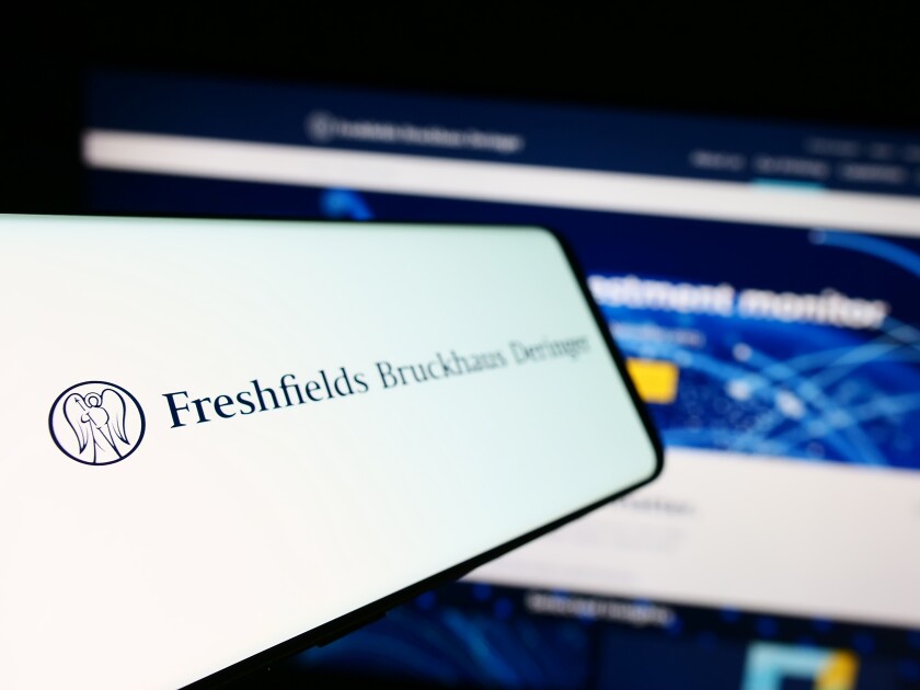 Stuttgart, Germany - 12-17-2023: Mobile phone with logo of British law firm Freshfields Bruckhaus Deringer LLP in front of business website. Focus on left of phone display.