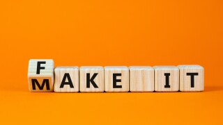 Fake it until you make it symbol. Turned a cube and changed words 'fake it' to 'make it'. Beautiful orange background. Business, and fake it till you make it concept. Copy space.