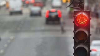 Traffic light in the city with red signal on the background of the road