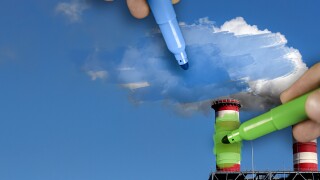 Hands painting blue and green pollution from a chimney