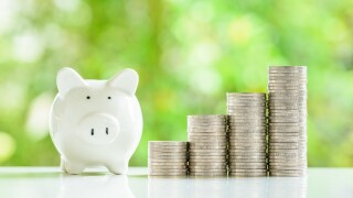 A cheerful piggybank with stacks of shiny coins nearby, represen