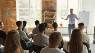 Male speaker giving presentation in hall at university workshop