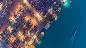 Container ship in export and import business and logistics. Shipping cargo to harbor by crane. Water transport International. Aerial view