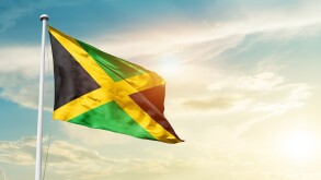 Jamaica national flag cloth fabric waving on the sky - Image