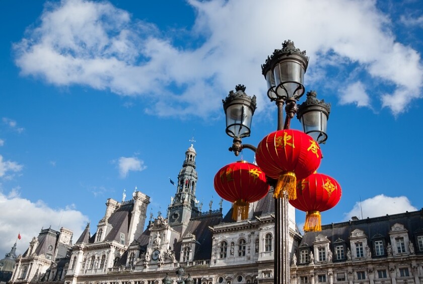Paris celebrates Chinese New Year. Street light decorated with Chinese traditional red lanterns and Paris City Hall (Hotel de Ville) at backgrounds.