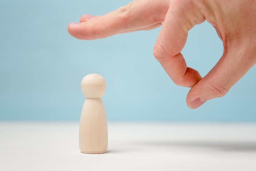 Male hand give a noogie to wooden figure.