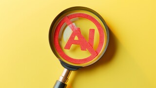Magnifying glass showing forbidden artificial intelligence symbol on yellow background