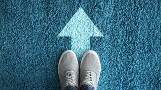 Man standing on carpet with arrow pointing in one direction. Con