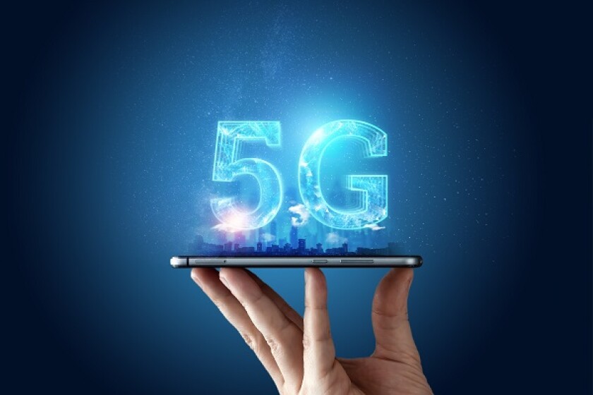 Creative background, male hand holding a phone with a 5G hologram on the background of the city. The concept of 5G network, high-speed mobile Internet, new generation networks. Copy space, Mixed media.