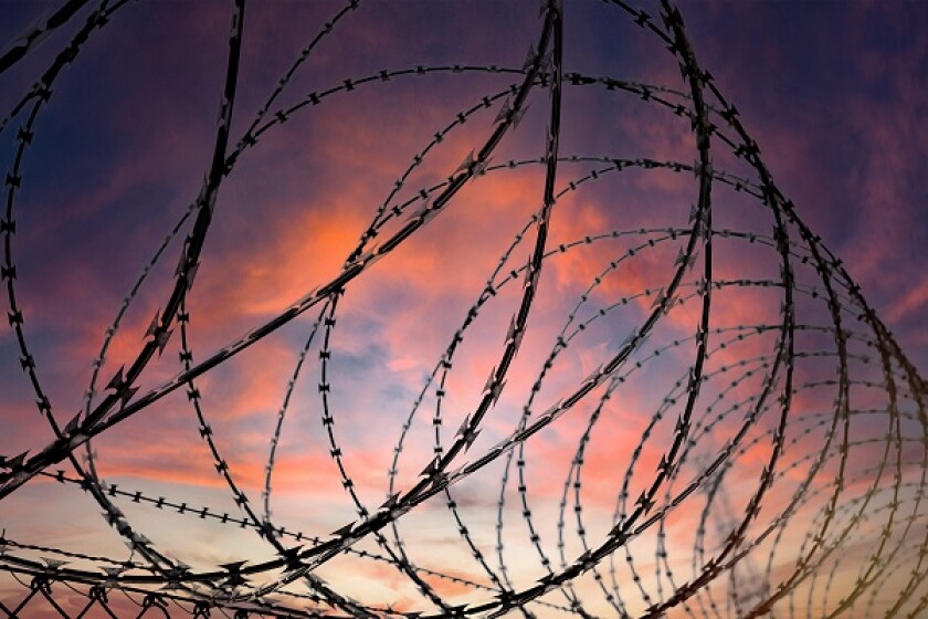 Silhouette of a barbed wire fence steel jail