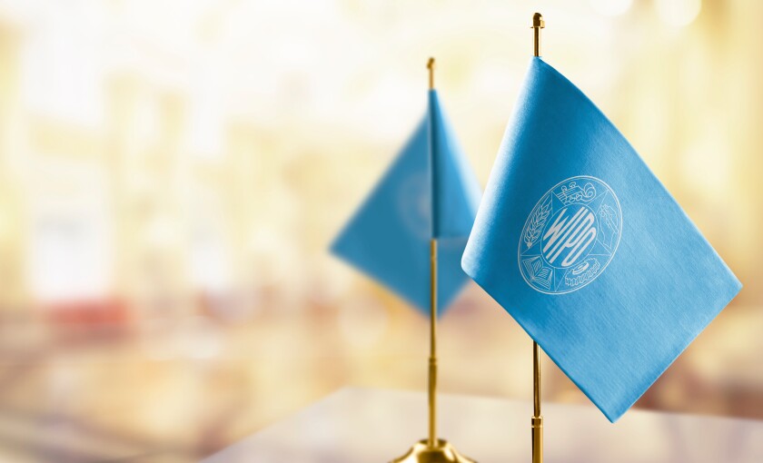 Small flags of the International Intellectual Property Organization on an abstract blurry background