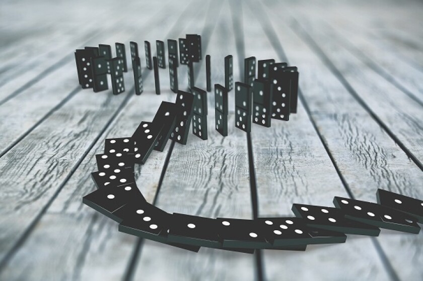 Black dominoes chain on a dark table. Domino effect concept
