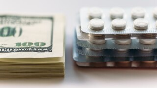 1707070 Bundle of money and  pack of medication tablets or drug