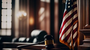 Mallet of judge in American courtroom. American flag in courtroo