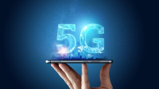 Creative background, male hand holding a phone with a 5G hologram on the background of the city. The concept of 5G network, high-speed mobile Internet, new generation networks. Copy space, Mixed media.