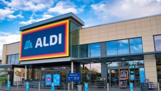 The frontage and brand logo of a branch of German discount retailer Aldi, taken in a local retail park on Wirral, UK on a sunny afternoon