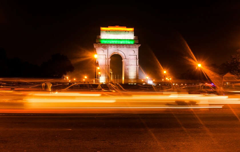 Colours of the Indian flag on the India Gate in New Delhi, with fast-moving traffic in the foreground.jpg