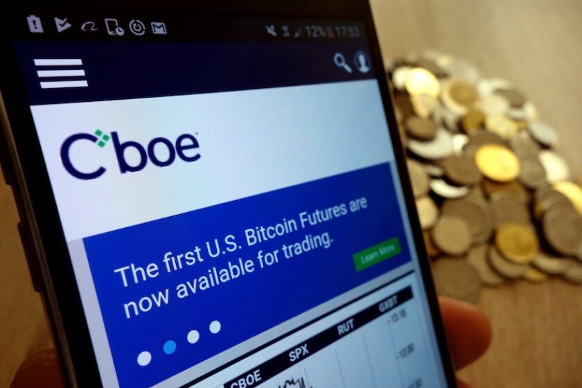 KONSKIE, POLAND - MAY 14, 2018: CBOE Global Markets website displayed on smartphone and stack of coins