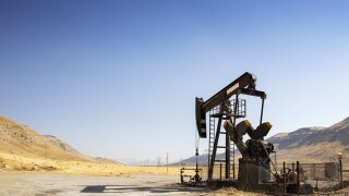 Oil drilling derricks at desert oilfield. Crude oil production from the ground. Oilfield services contractor. Oil drill rig and pump jack. Petroleum production, natural gas, liquids, NGL, additive.