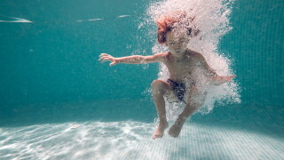Underwater shot of boy jumping in pool