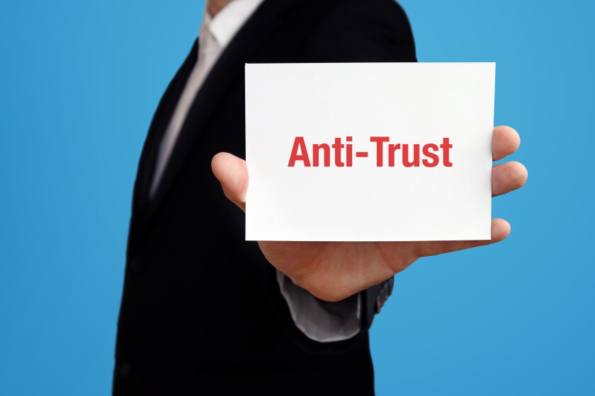 Anti-Trust. Geschäftsmann im Anzug hält Karte in die Kamera. Der Begriff Anti-Trust steht im Schild. Symbol für Business, Finanzen, Statistik, Analyse, Wirtschaft