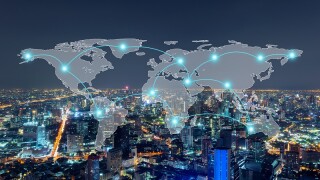 Digital network connection lines of Bangkok Downtown, Thailand with world map. Financial district and business centers in smart urban city in Asia. Skyscraper and high-rise buildings at night.