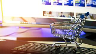 Mini shopping trolley on keyboard in front of monitor
