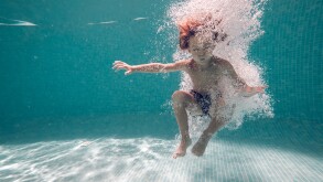 Underwater shot of boy jumping in pool